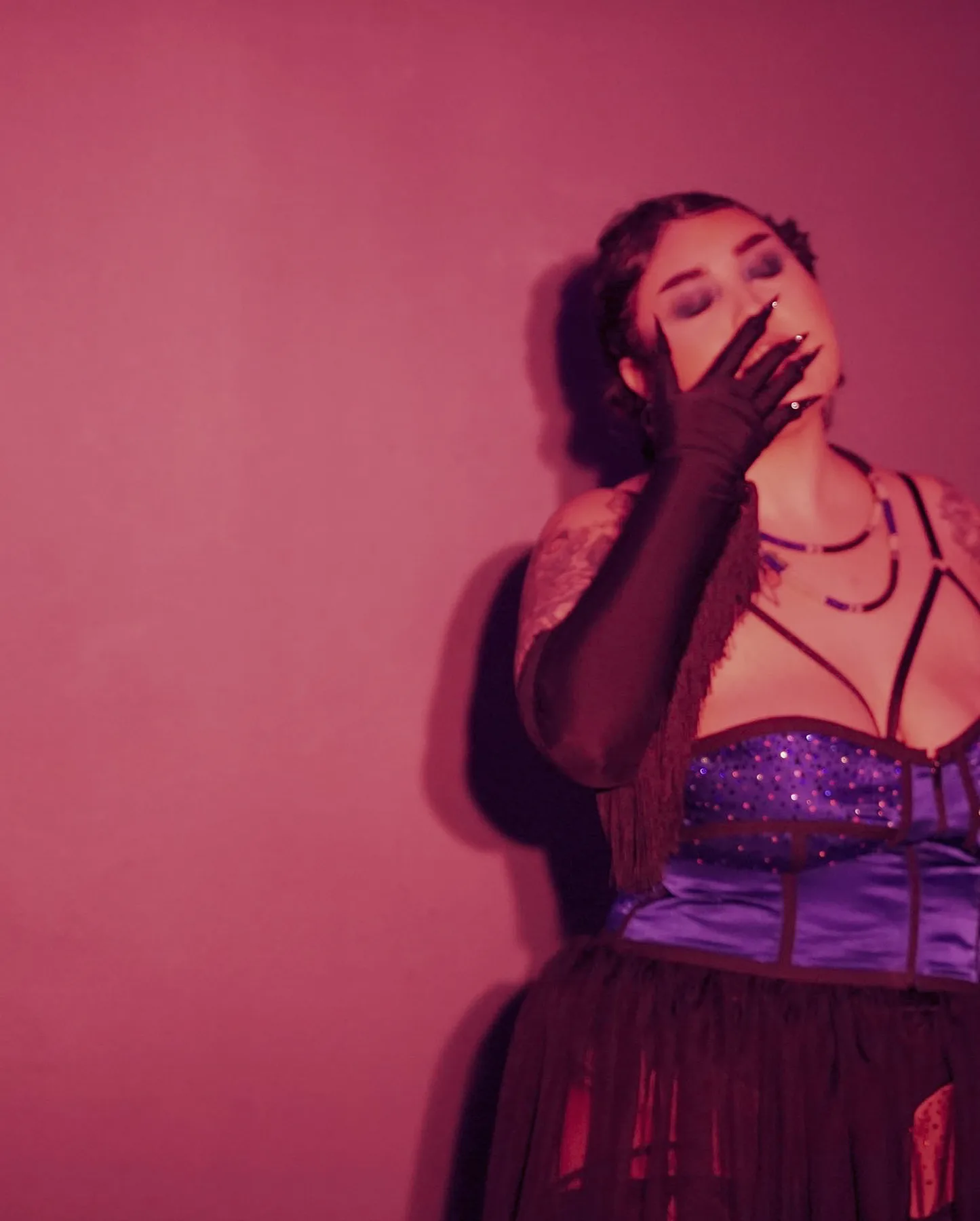 Hope-Adina Adler posing against a pink background.