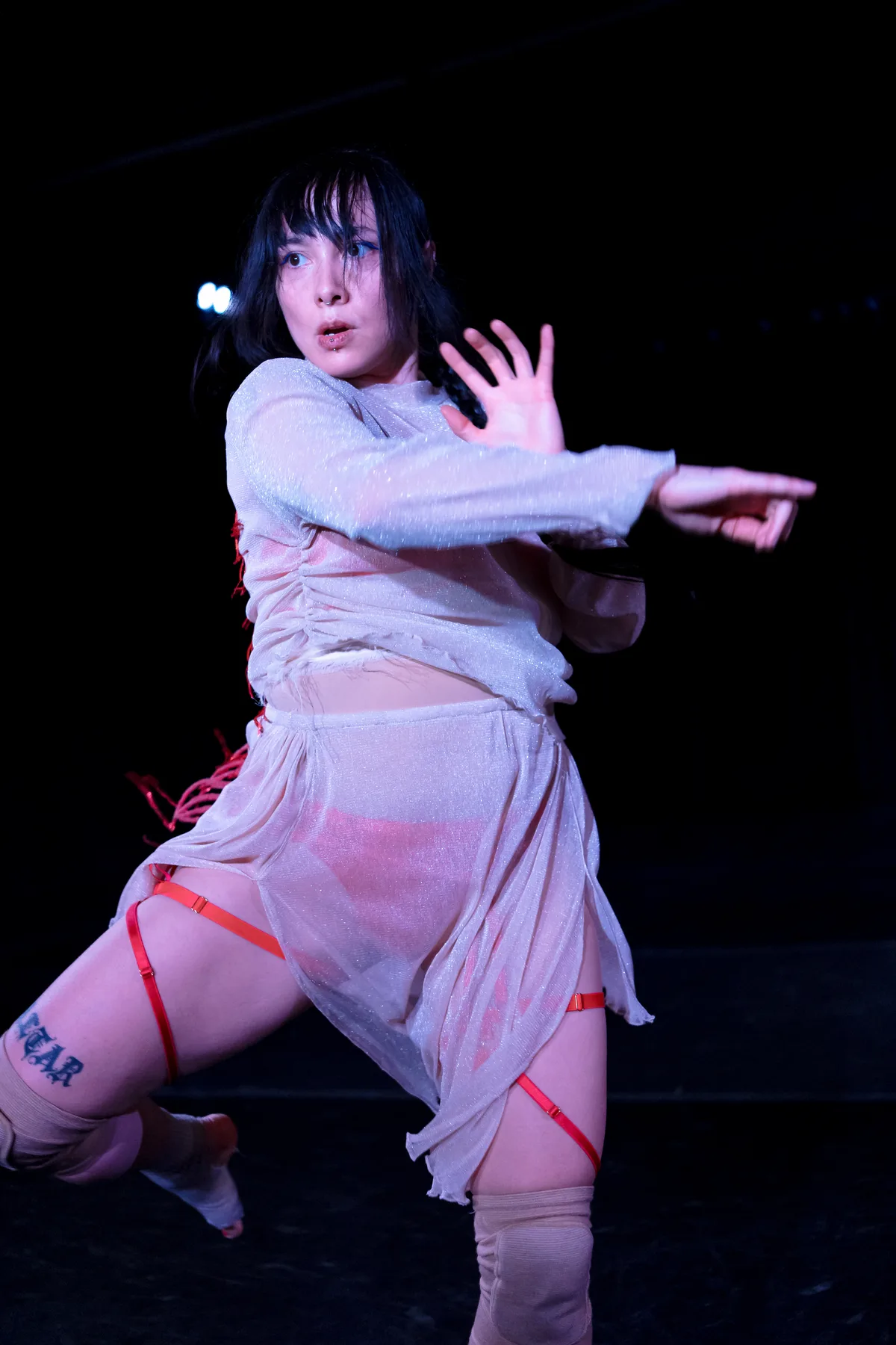 Lux Gow-Habrich performing Blood Song in a white costume with red beaded work.