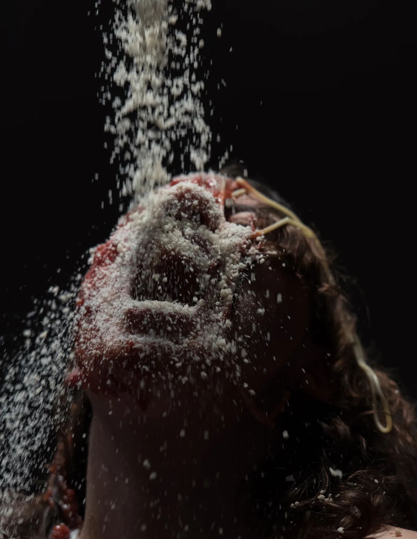 Tess Martens performance image with powder falling across the artist's face.